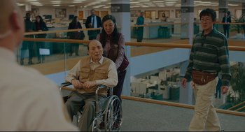 An older man in a wheelchair in an office building
