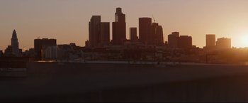 Movie still from “Come and Find Me” (2016), directed by Zack Whedon – A view of a city skyline at sunset; Extreme Wide shot, Low angle