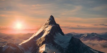 Movie still from “Coming 2 America” (2021), directed by Craig Brewer – The sun is setting over a mountain range; Extreme Wide shot, High angle