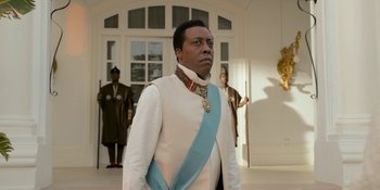 Movie still from “Coming 2 America” (2021), directed by Craig Brewer – A man in a white and blue suit standing in front of a building; Close Up shot, Low angle