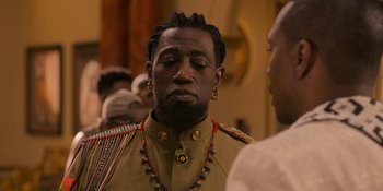 Movie still from “Coming 2 America” (2021), directed by Craig Brewer – A person with a beard wearing a military uniform; Close Up shot, Over the shoulder angle