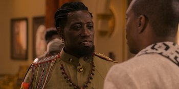 Movie still from “Coming 2 America” (2021), directed by Craig Brewer – A person with a beard wearing a uniform; Close Up shot, Over the shoulder angle