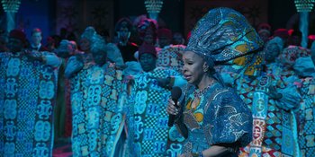 Movie still from “Coming 2 America” (2021), directed by Craig Brewer – A group of women in colorful dresses and headdresses; Medium shot, Over the shoulder angle