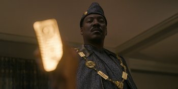 Movie still from “Coming 2 America” (2021), directed by Craig Brewer – A man wearing a hat and a chain around his neck; Close Up shot, Low angle