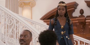Movie still from “Coming 2 America” (2021), directed by Craig Brewer – A woman standing on a staircase wearing a crown; Medium shot, Over the shoulder angle