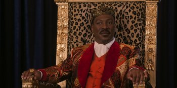 Movie still from “Coming 2 America” (2021), directed by Craig Brewer – A man wearing a suit and a crown in front of an animal print chair; Close Up shot, Low angle