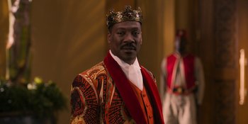 Movie still from “Coming 2 America” (2021), directed by Craig Brewer – A man wearing a suit and a crown in front of a curtain; Close Up shot, Low angle