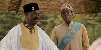Movie still from “Coming 2 America” (2021), directed by Craig Brewer – Two men standing next to each other in traditional clothing; Close Up shot, Over the shoulder angle