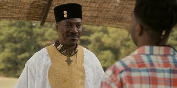 Movie still from “Coming 2 America” (2021), directed by Craig Brewer – A man in a traditional african outfit; Close Up shot, Over the shoulder angle