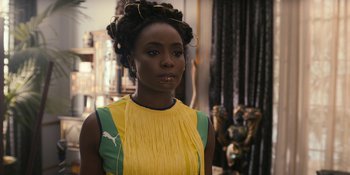 Movie still from “Coming 2 America” (2021), directed by Craig Brewer – A woman in a yellow and green dress; Close Up shot, Over the shoulder angle