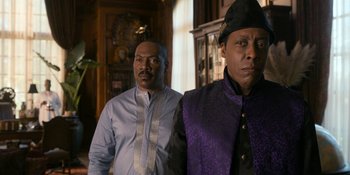 Movie still from “Coming 2 America” (2021), directed by Craig Brewer – A couple of men standing next to each other in a room; Medium shot, Over the shoulder angle