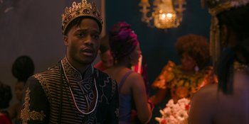 Movie still from “Coming 2 America” (2021), directed by Craig Brewer – A man wearing a crown standing in front of a group of people; Close Up shot, Over the shoulder angle