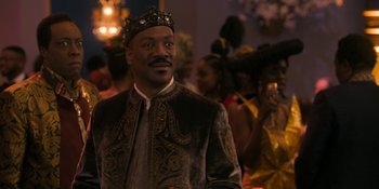 Movie still from “Coming 2 America” (2021), directed by Craig Brewer – A man wearing a crown standing in front of a group of people; Close Up shot, Over the shoulder angle