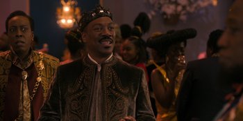 Movie still from “Coming 2 America” (2021), directed by Craig Brewer – A man wearing a crown standing in front of a group of people; Medium shot, Over the shoulder angle