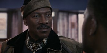 Movie still from “Coming 2 America” (2021), directed by Craig Brewer – A person wearing a hat and a necklace; Close Up shot, Low angle