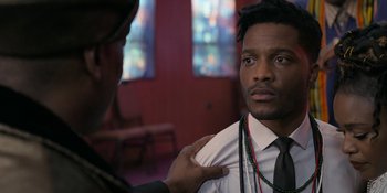 Movie still from “Coming 2 America” (2021), directed by Craig Brewer – A man in a suit and tie is looking at another man in a tie; Close Up shot, Over the shoulder angle