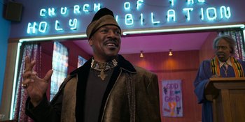 Movie still from “Coming 2 America” (2021), directed by Craig Brewer – A man wearing a hat and a jacket; Medium shot, Low angle