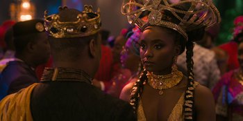Movie still from “Coming 2 America” (2021), directed by Craig Brewer – A man and a woman in a gold dress and crown; Close Up shot, Over the shoulder angle
