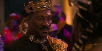 Movie still from “Coming 2 America” (2021), directed by Craig Brewer – A man wearing a gold crown and a black suit; Close Up shot, Over the shoulder angle