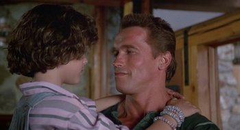 Movie still from “Commando” (1985), directed by Mark L. Lester – A man and a boy are looking into each others eyes; Close Up shot, Over the shoulder angle