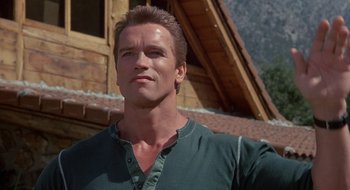 Movie still from “Commando” (1985), directed by Mark L. Lester – A person wearing a green shirt; Close Up shot, Low angle