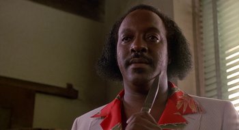 Movie still from “Commando” (1985), directed by Mark L. Lester – A person holding a knife in his hand; Close Up shot, Low angle