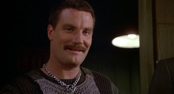 Movie still from “Commando” (1985), directed by Mark L. Lester – A person wearing a necklace; Close Up shot, Low angle