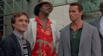 Movie still from “Commando” (1985), directed by Mark L. Lester – A group of men standing next to each other; Medium shot, Low angle