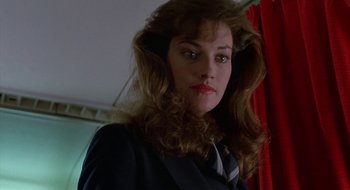 Movie still from “Commando” (1985), directed by Mark L. Lester – A person wearing a suit and tie; Close Up shot, Low angle