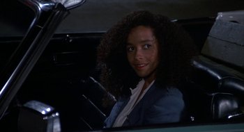 Movie still from “Commando” (1985), directed by Mark L. Lester – A woman sitting in the back seat of a car; Close Up shot, High angle