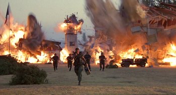 Movie still from “Commando” (1985), directed by Mark L. Lester – A group of people running through a field; Extreme Wide shot, Low angle