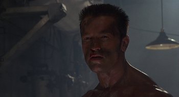 Movie still from “Commando” (1985), directed by Mark L. Lester – A person wearing a shirt; Close Up shot, Low angle