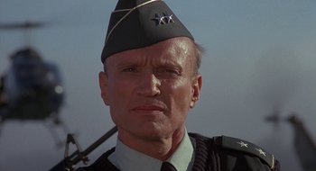 Movie still from “Commando” (1985), directed by Mark L. Lester – A person wearing a uniform; Close Up shot, Low angle