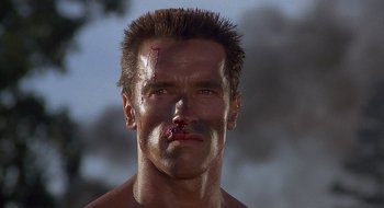 Movie still from “Commando” (1985), directed by Mark L. Lester – A person with a cut on his face; Close Up shot, Low angle