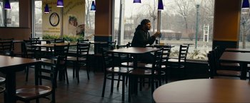 Movie still from “Compliance” (2012), directed by Craig Zobel – A man sitting at a table in front of a window; Wide shot, High angle