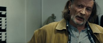 Movie still from “Compliance” (2012), directed by Craig Zobel – A person with long hair and a beard; Close Up shot, Over the shoulder angle