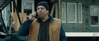 Movie still from “Compliance” (2012), directed by Craig Zobel – A man talking on a cell phone while wearing a hat; Close Up shot, Over the shoulder angle