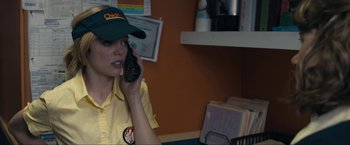 Movie still from “Compliance” (2012), directed by Craig Zobel – A woman talking on a cell phone while wearing a hat; Close Up shot, Over the shoulder angle