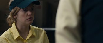 Movie still from “Compliance” (2012), directed by Craig Zobel – A woman wearing a yellow shirt and a blue hat; Close Up shot, Over the shoulder angle