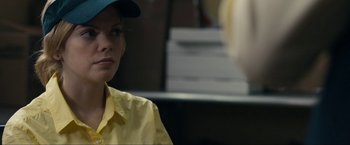 Movie still from “Compliance” (2012), directed by Craig Zobel – A woman wearing a yellow shirt and a blue hat; Close Up shot, Over the shoulder angle