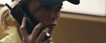 Movie still from “Compliance” (2012), directed by Craig Zobel – A person talking on a cell phone; Close Up shot, Low angle