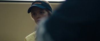 Movie still from “Compliance” (2012), directed by Craig Zobel – A woman wearing a hat and a yellow shirt; Close Up shot, Over the shoulder angle
