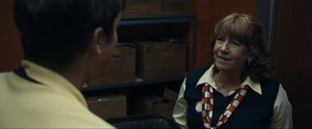 Movie still from “Compliance” (2012), directed by Craig Zobel – A woman wearing a tie talking to a man; Medium shot, Over the shoulder angle