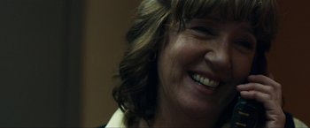 Movie still from “Compliance” (2012), directed by Craig Zobel – A woman's face smiling; Close Up shot, Over the shoulder angle