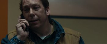 Movie still from “Compliance” (2012), directed by Craig Zobel – A person wearing a brown jacket; Close Up shot, Over the shoulder angle