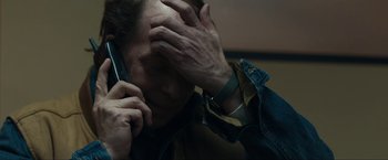 Movie still from “Compliance” (2012), directed by Craig Zobel – A man holding his head while talking on a phone; Close Up shot, High angle