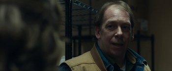 Movie still from “Compliance” (2012), directed by Craig Zobel – A person wearing a vest; Close Up shot, Over the shoulder angle