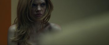 Movie still from “Compliance” (2012), directed by Craig Zobel – A woman with long blonde hair is looking at the camera; Close Up shot, Over the shoulder angle