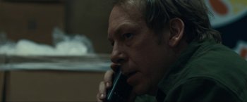 Movie still from “Compliance” (2012), directed by Craig Zobel – A person talking on a cell phone; Close Up shot, Low angle