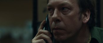 Movie still from “Compliance” (2012), directed by Craig Zobel – A person talking on a cell phone; Close Up shot, Low angle